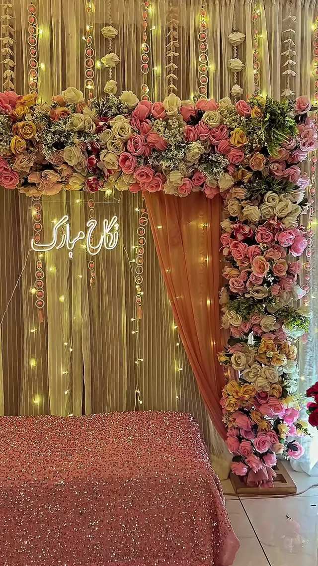 A Nikah stage by MM Decor Studio: white florals, fairy lights and a lit name sign